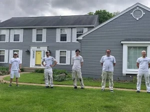 Tribble Painting Company workers pose in front of a painted home - how to paint shutters